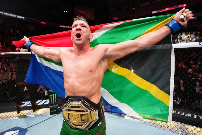 Dricus Du Plessis with the South African flag and the UFC middleweight belt